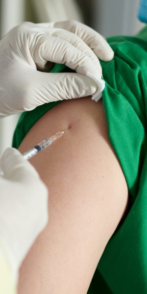 Close-up image of doctor making injection of vaccine in shoulder of medical nurse